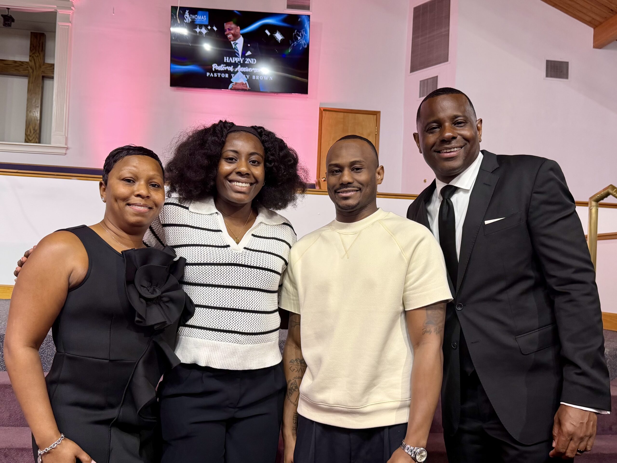 Pastor Terry Brown and his wife smiling with two young adult members.