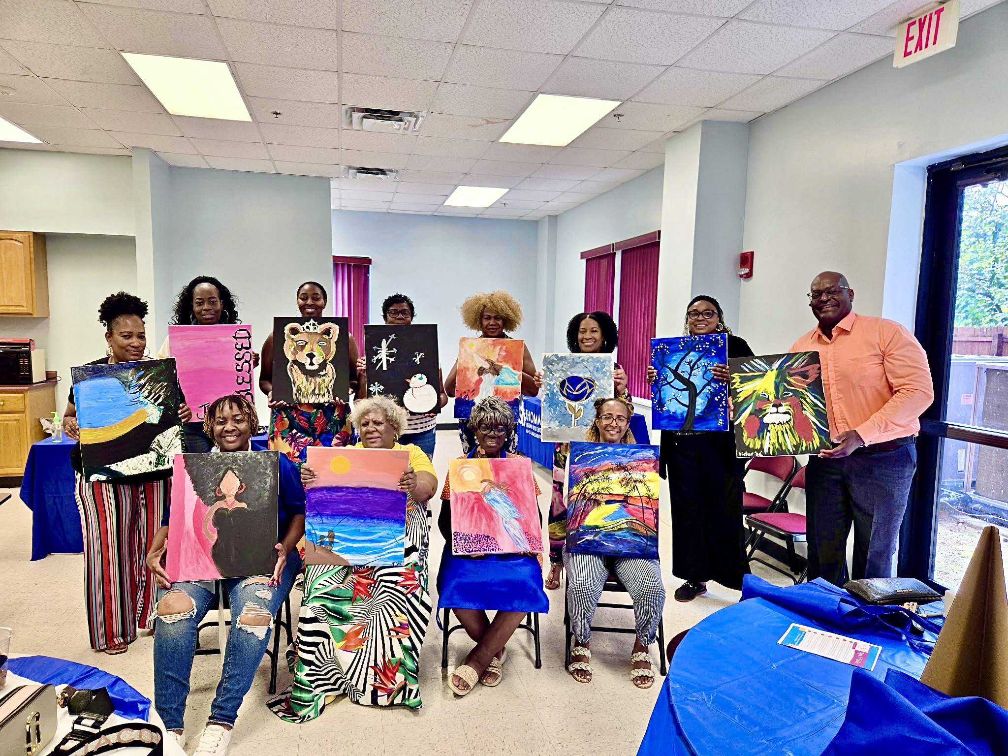 Members sharing paintings they created during a painting class